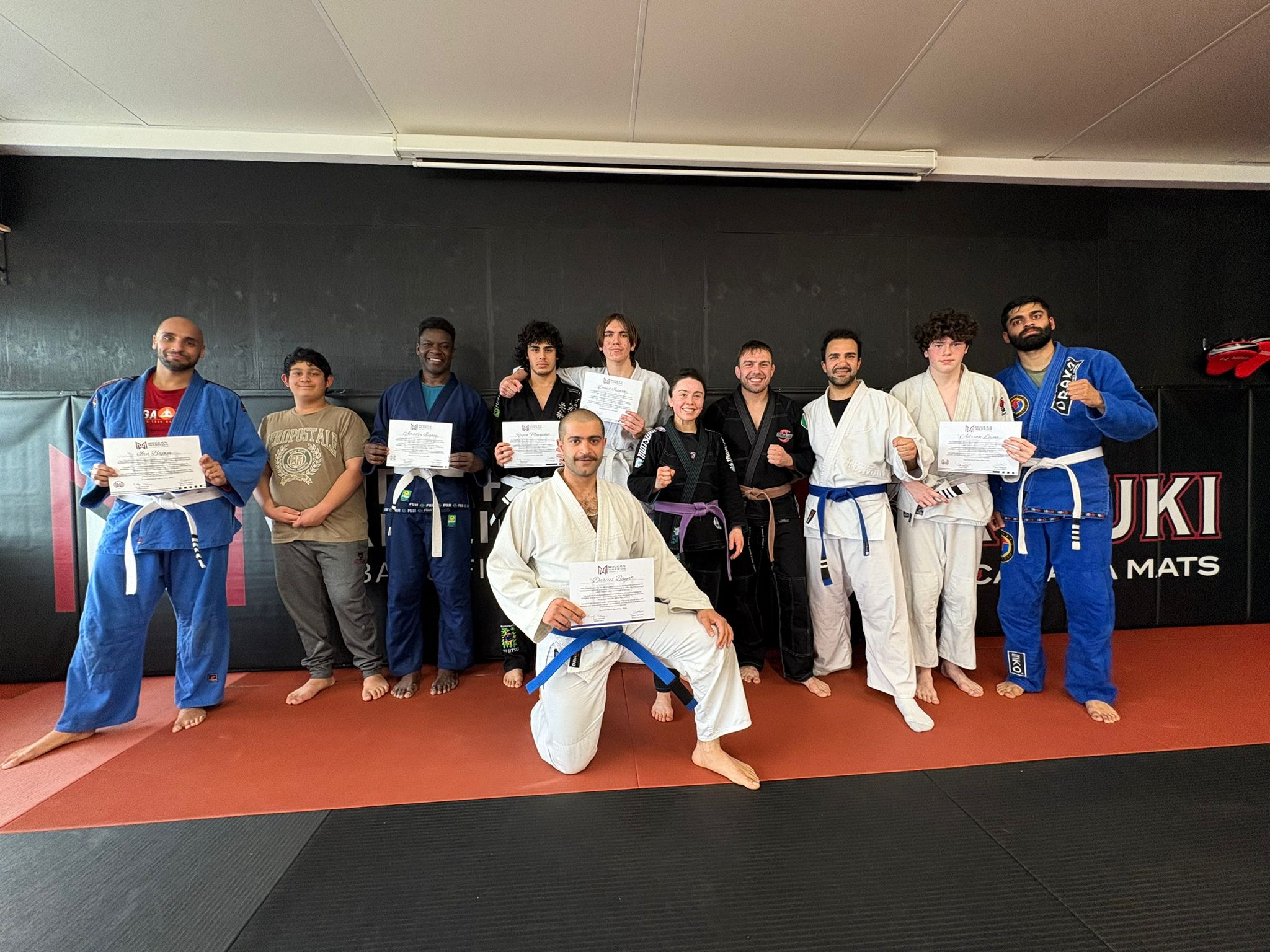 Jiu-Jitsu exam awards — May 2026 Modern Warrior Jiu-Jitsu students with certificates after exam and stripe awards in New Westminster