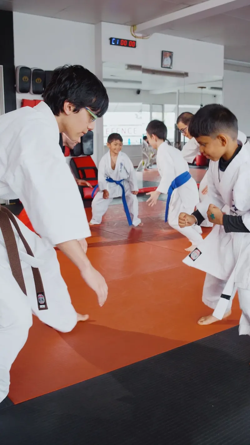 Kids practising karate stances with a coach during after-school martial arts in New Westminster