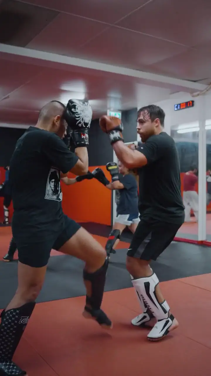 Two students in gloves and shin guards during a controlled striking round at Modern Warrior Academy.